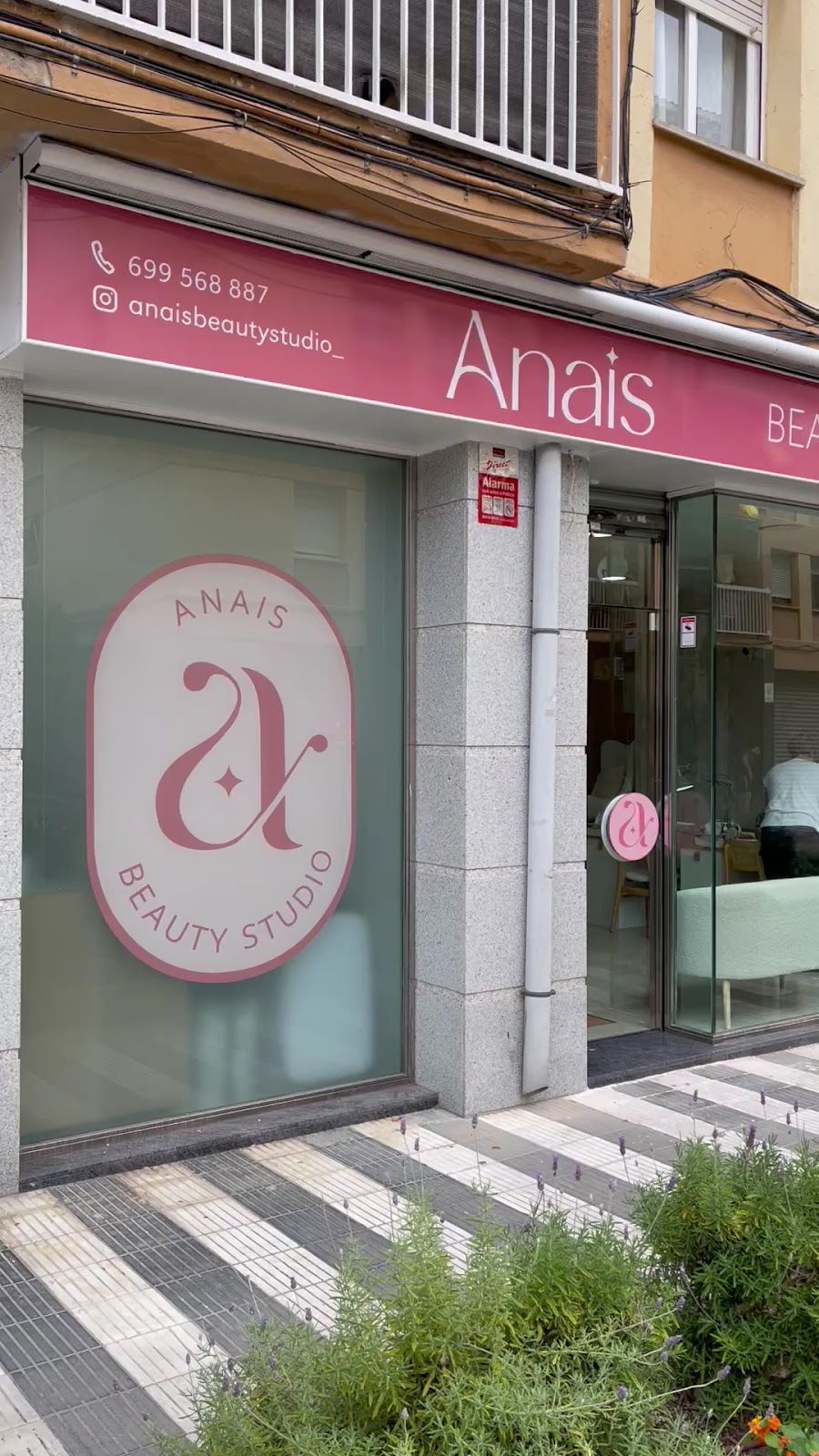 Fachada de Anais Beauty Studio en Les Roquetes, con el rótulo rosa y el logotipo en el escaparate