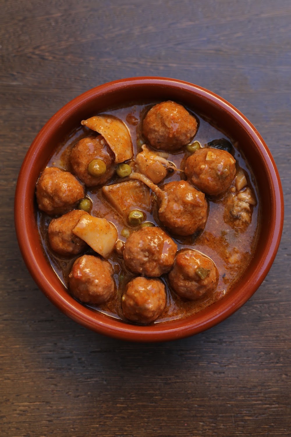 Albóndigas con sepia y guisantes en cazuela de barro