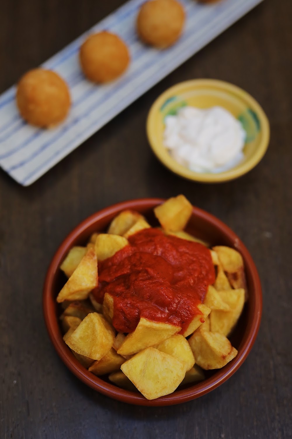 Patatas bravas con salsa y all i oli en cazuela de barro