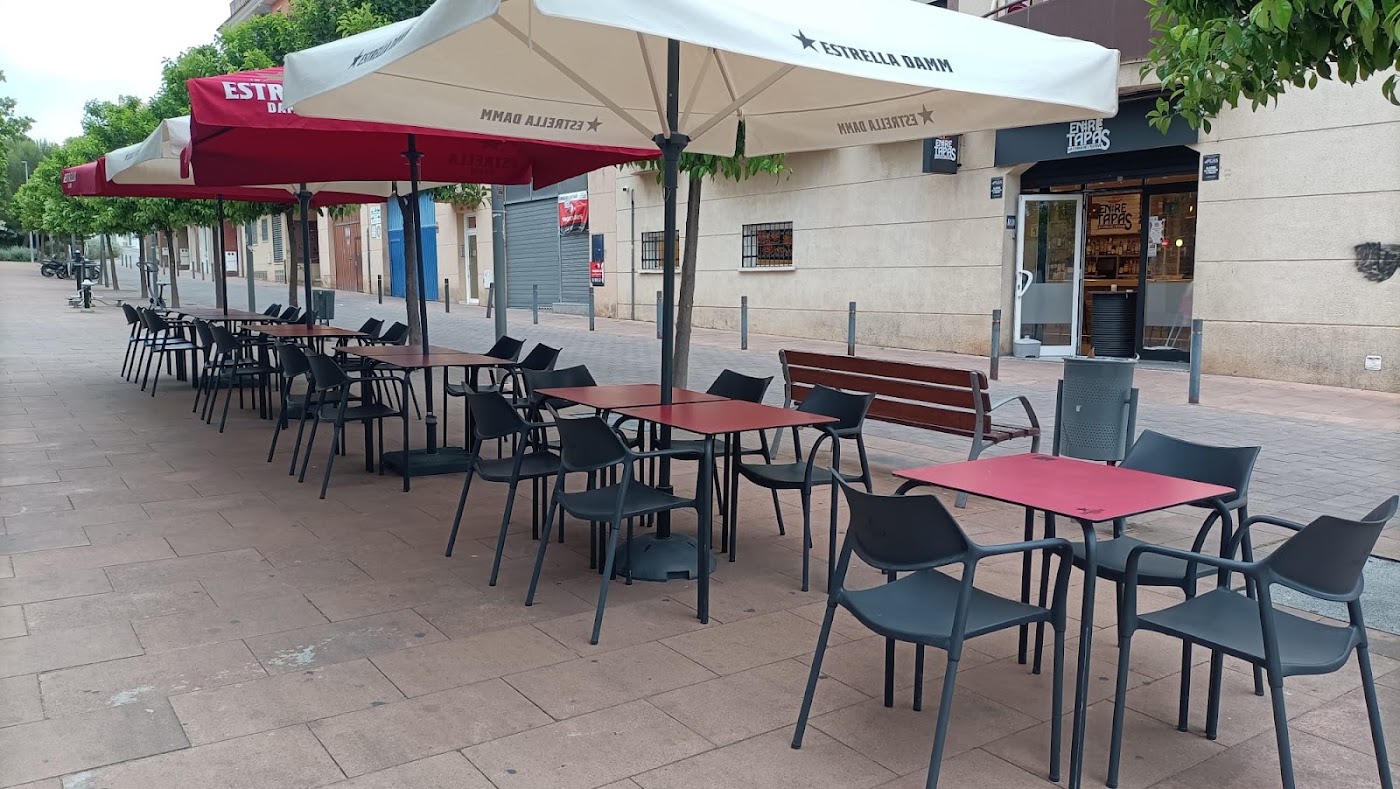 Terraza de Entre Tapas con sombrillas y mesas en Les Roquetes