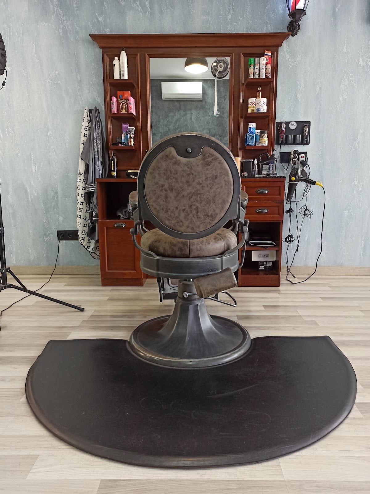 Puesto de barbero de Luxury BarberShop con sillón vintage de cuero y mueble de madera